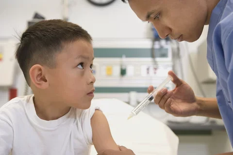 Medical provider giving a vaccine to a child.