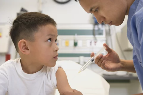 Medical provider giving a vaccine to a child.
